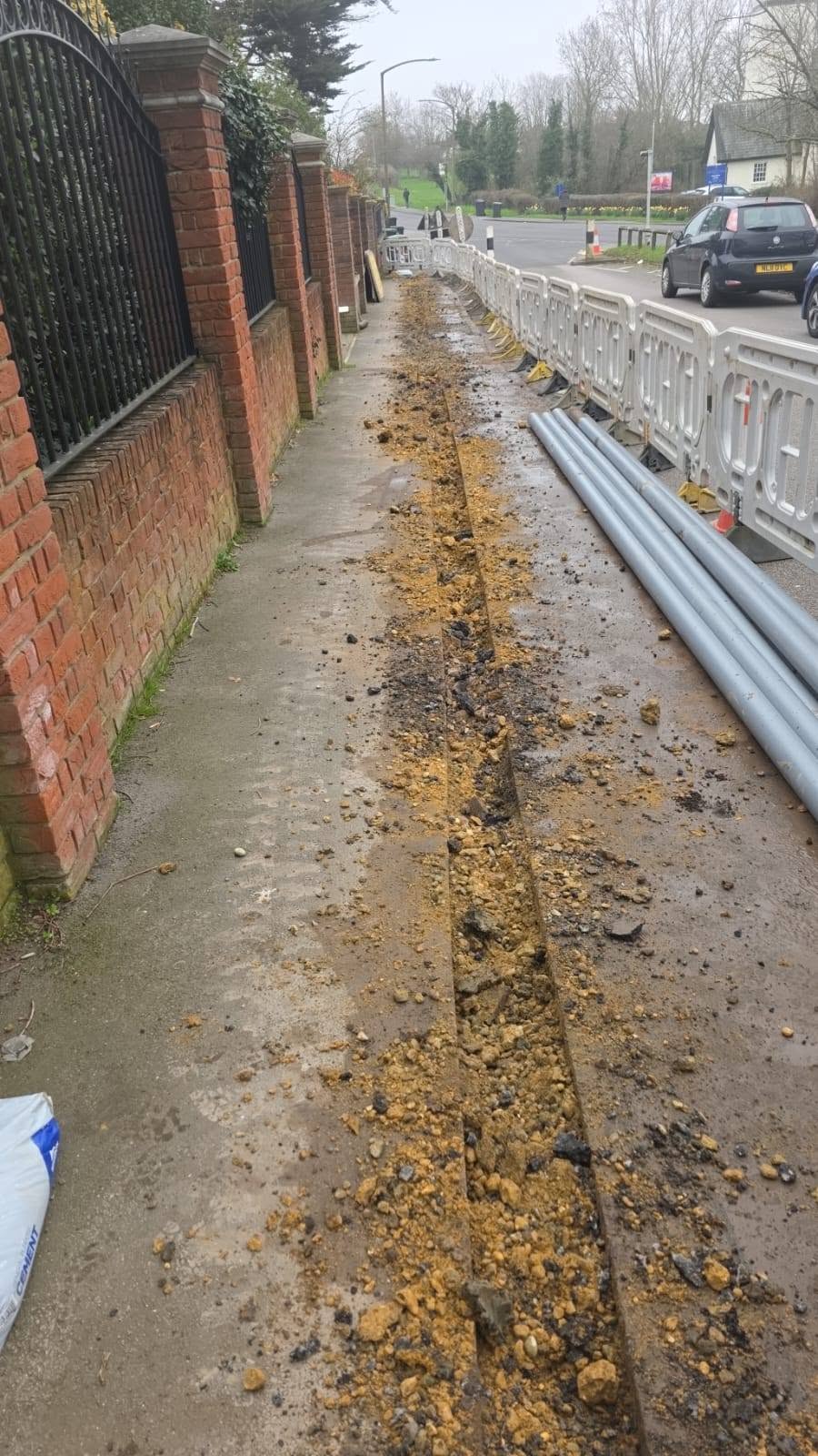 Street-side trenching work area with materials staged along the path